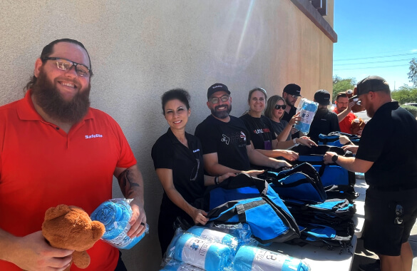 Group of associates filling duffel bags for foster youth