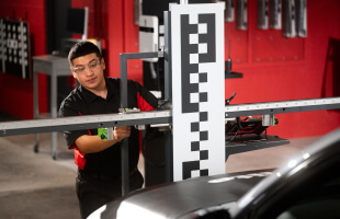 A Safelite technician wearing gloves recalibrating a vehicle’s ADAS system